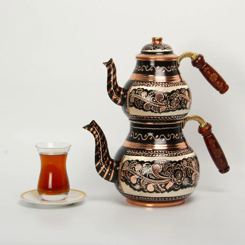 Una tetera turca de cobre grabado con teteras dobles que le permiten  preparar té en una, mientras que el agua caliente de la tetera más grande  se usa para diluir tazas individuales